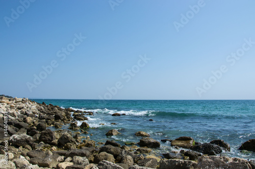 Beautiful wild beach landscape, sunny day, water waves hitting the cliffs, nature summertime scene © Len0r