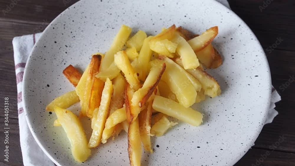 In a plate put fried potatoes. French fries on a plate. Close up. In a plate put fried potatoes. French fries on a plate. Close up.