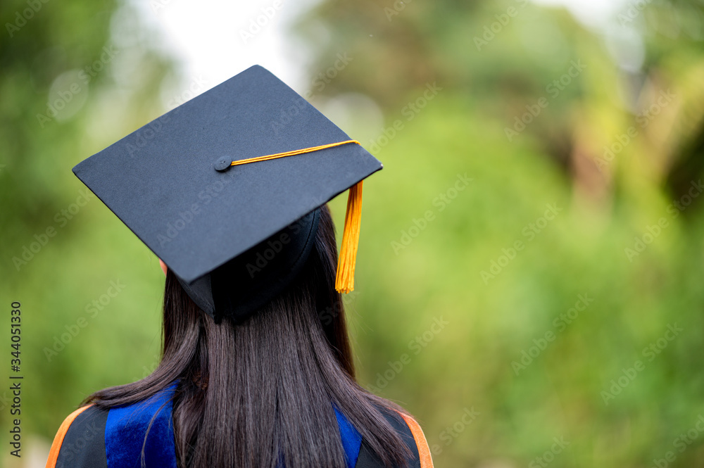 closeup behind a female college graduate wearing a black fringe gown and a  black hat, Concept of Successful Education in Hight School,Congratulated  Degree Stock Photo