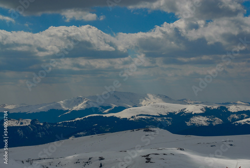 mountain with snow and sun in the clouds