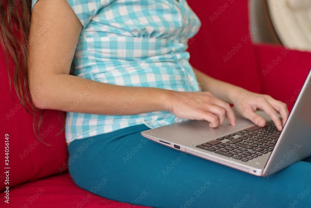 Naklejka premium Midsection of young woman using laptop