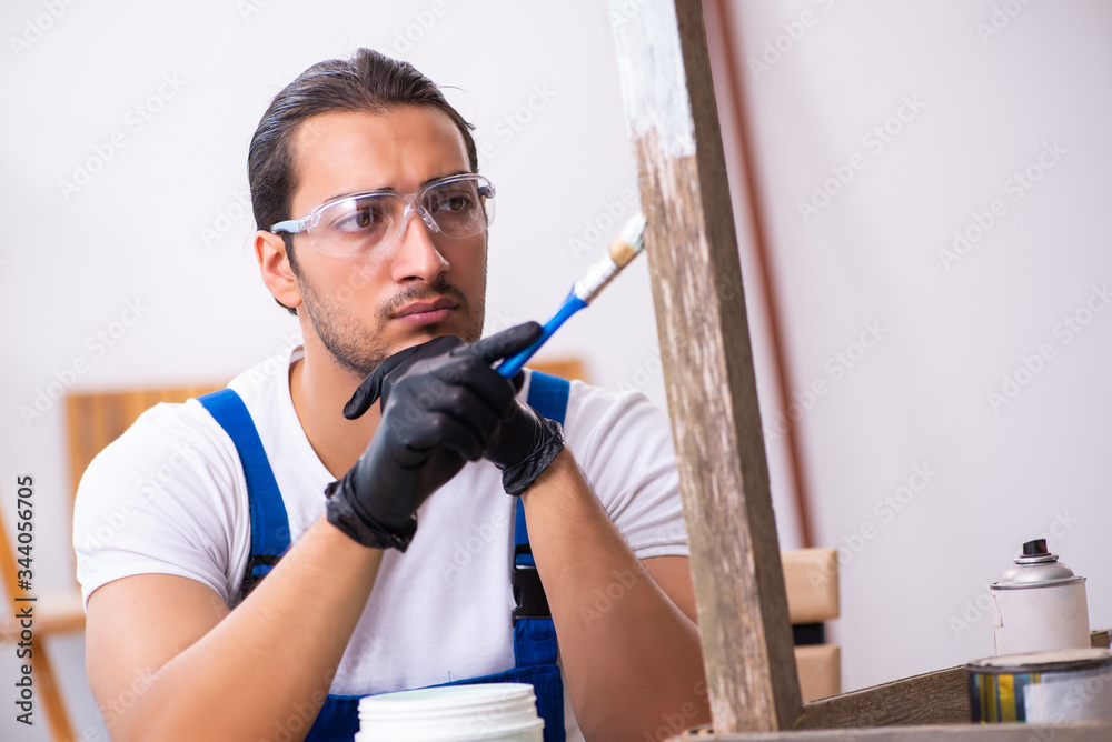 Fototapeta premium Young male contractor working in workshop