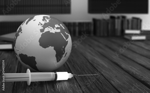 The globe world and syringe with vaccines on wooden table. Covid-19 prevention concepts.
