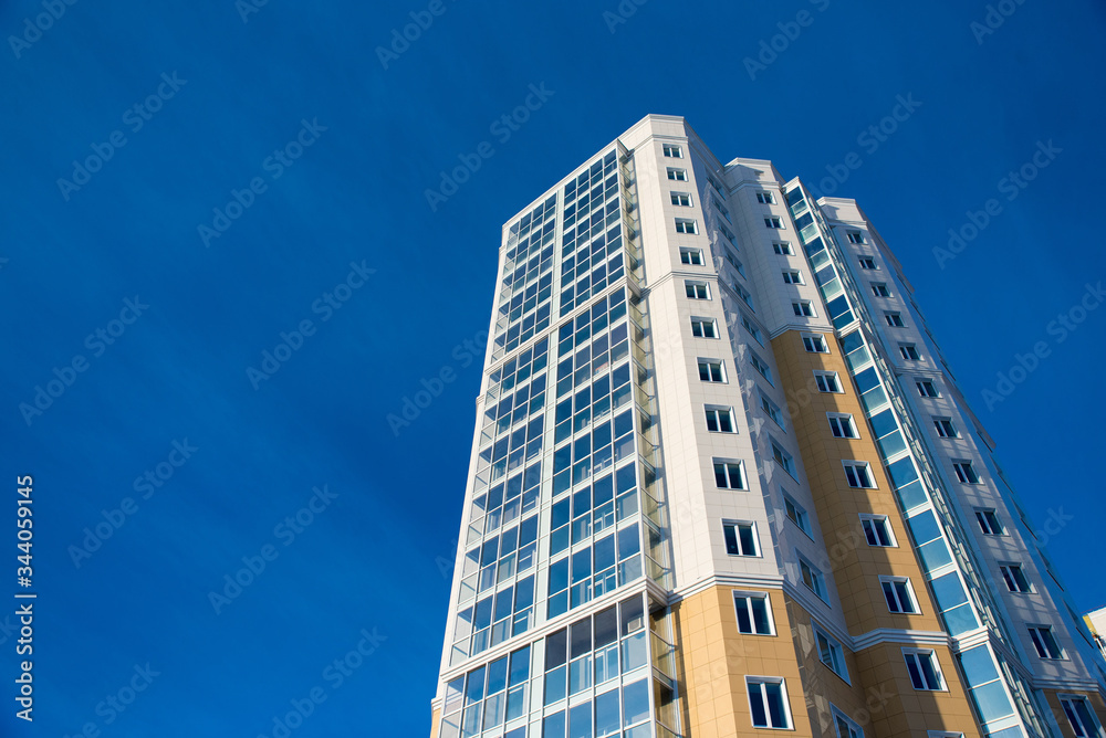 New multi-storey residential building with Windows and balconies against the blue sky