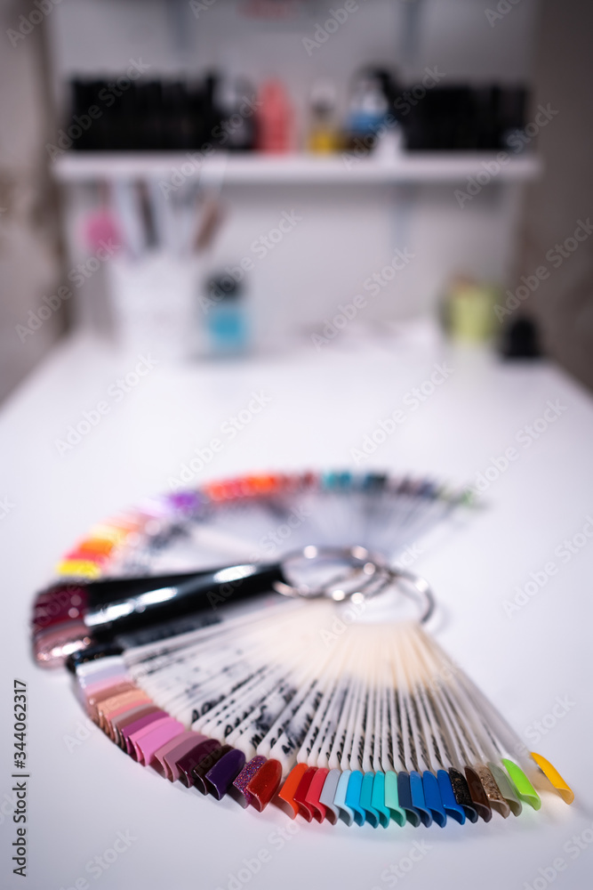 manicure artist making nail polish procedure with color laquer palette
