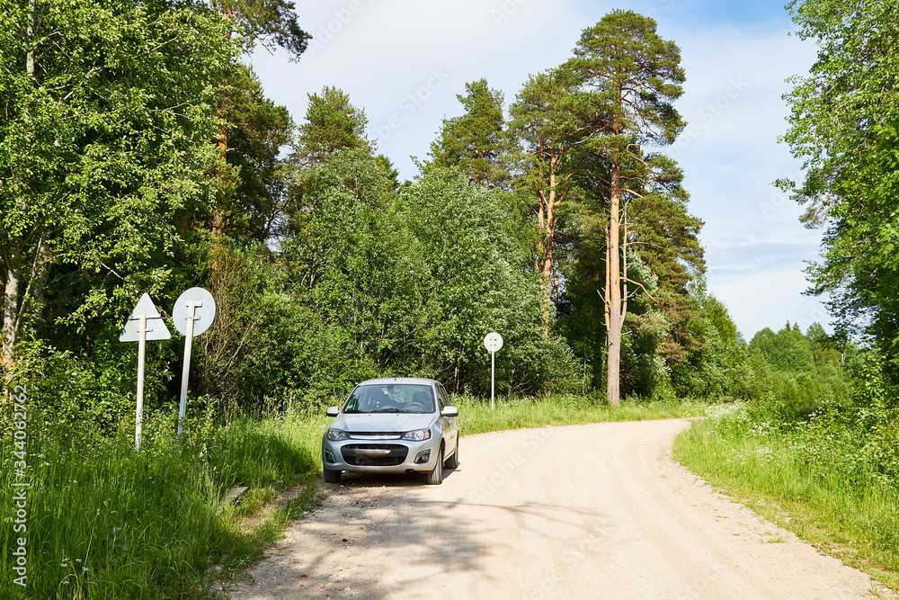 Car on an old road on summer day in forest