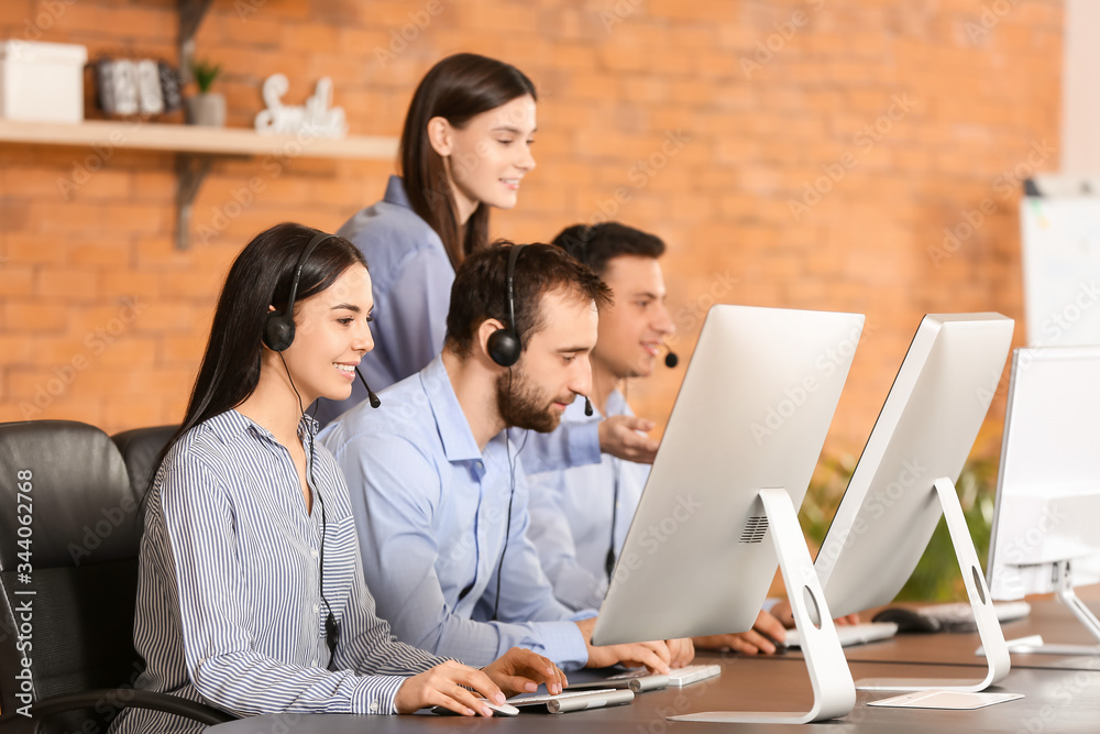 Professional technical support agent teaching young people in office Professional technical support agent teaching young people in office