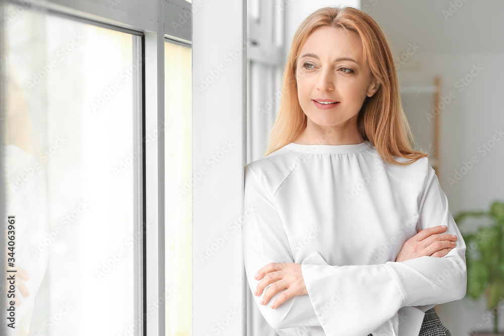 Portrait of stylish businesswoman near window in office Portrait of stylish businesswoman near window in office