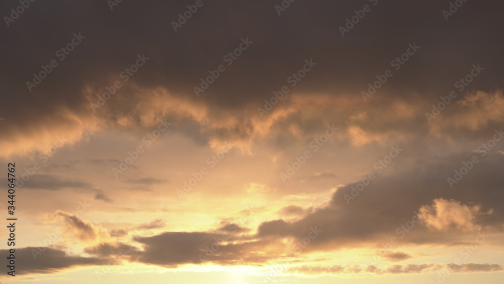 Beautiful evening blue sky at sunset with flaming bright light clouds. A warm summer evening at sunset. Beautiful evening blue sky at sunset with flaming bright light clouds. A warm summer evening at sunset.