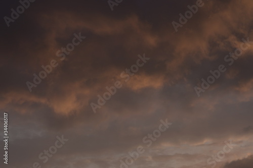 Beautiful evening blue sky at sunset with flaming bright light clouds. A warm summer evening at sunset.