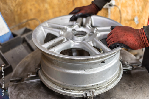 Professional worker repairs car tire