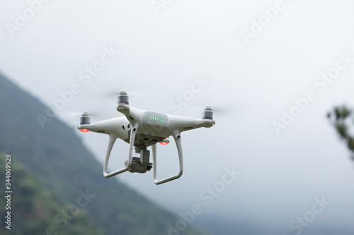Fototapeta Naklejka Na Ścianę i Meble -  White drone with camera flying in spring mountains