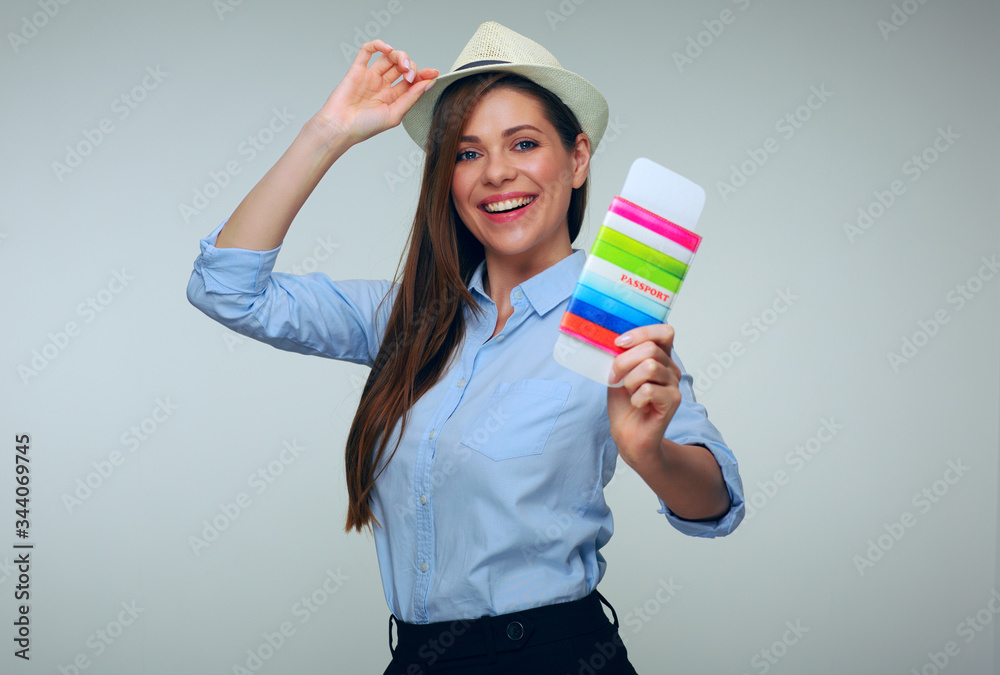 Woman in blue shirt wearing hat holding passport and ticket. Woman in blue shirt wearing hat holding passport and ticket.
