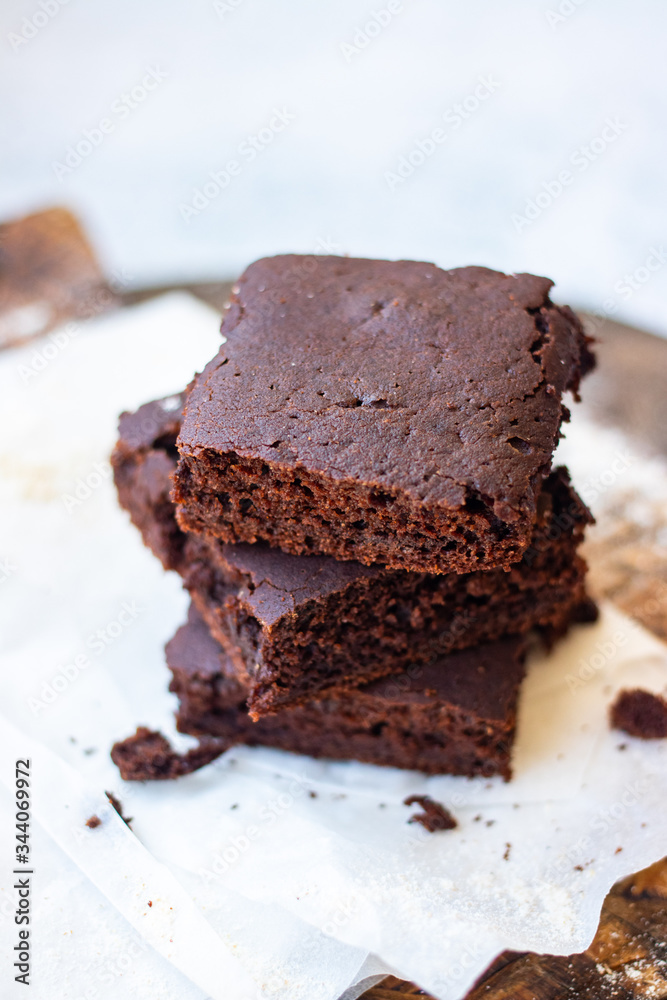 Baked chocolate vegan dessert. Homemade brownie cake with  sweet cream spread. 