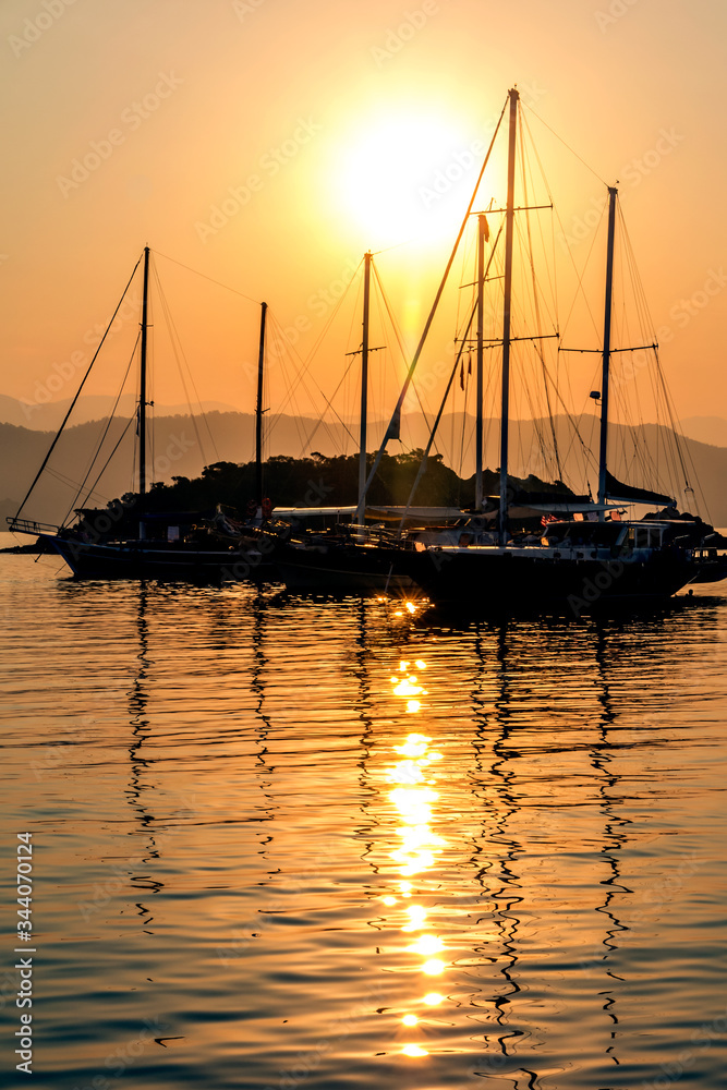 Sunset on the sea, with gullets and yachts moored off the sandbank at Yassica Alderi, Gocek, Turkey