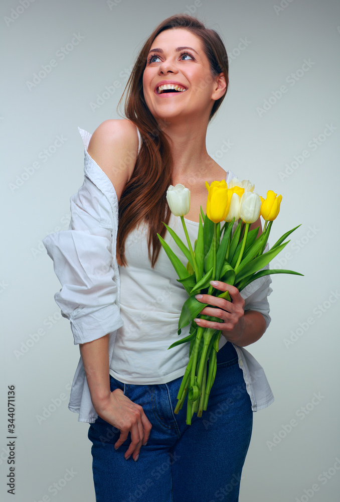Happy woman holding tulips flowers and looking away Happy woman holding tulips flowers and looking away