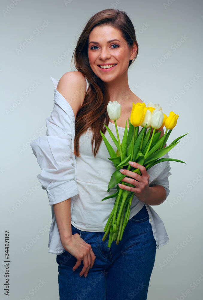 Happy woman with toothy smile dressed casual white shirt holding flowers. Happy woman with toothy smile dressed casual white shirt holding flowers.