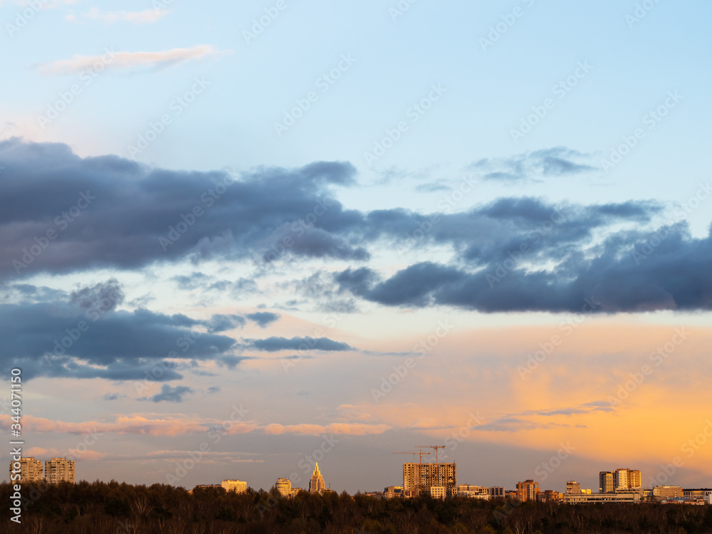 dark clouds in blue sky over urban houses at spring sunset in Moscow city