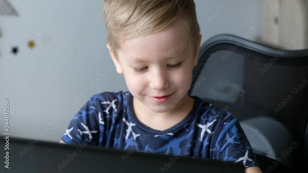 Little boy kid learning or playing on laptop at home, distance education Little boy kid learning or playing on laptop at home, distance education
