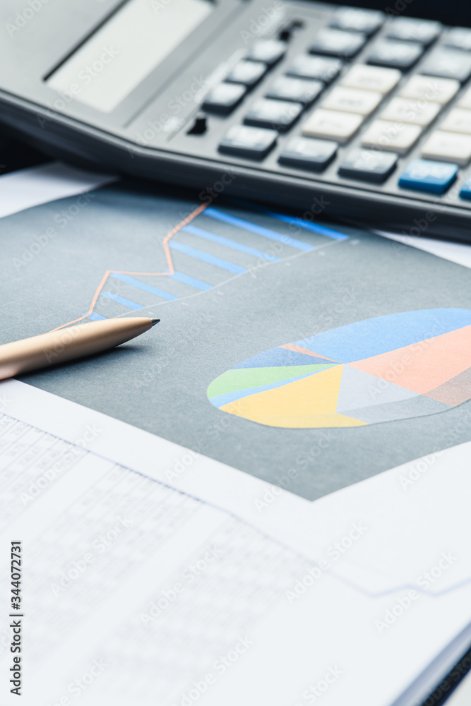 Business financial documents, office calculator and pen on the table. Numbers and graphs Business financial documents, office calculator and pen on the table. Numbers and graphs