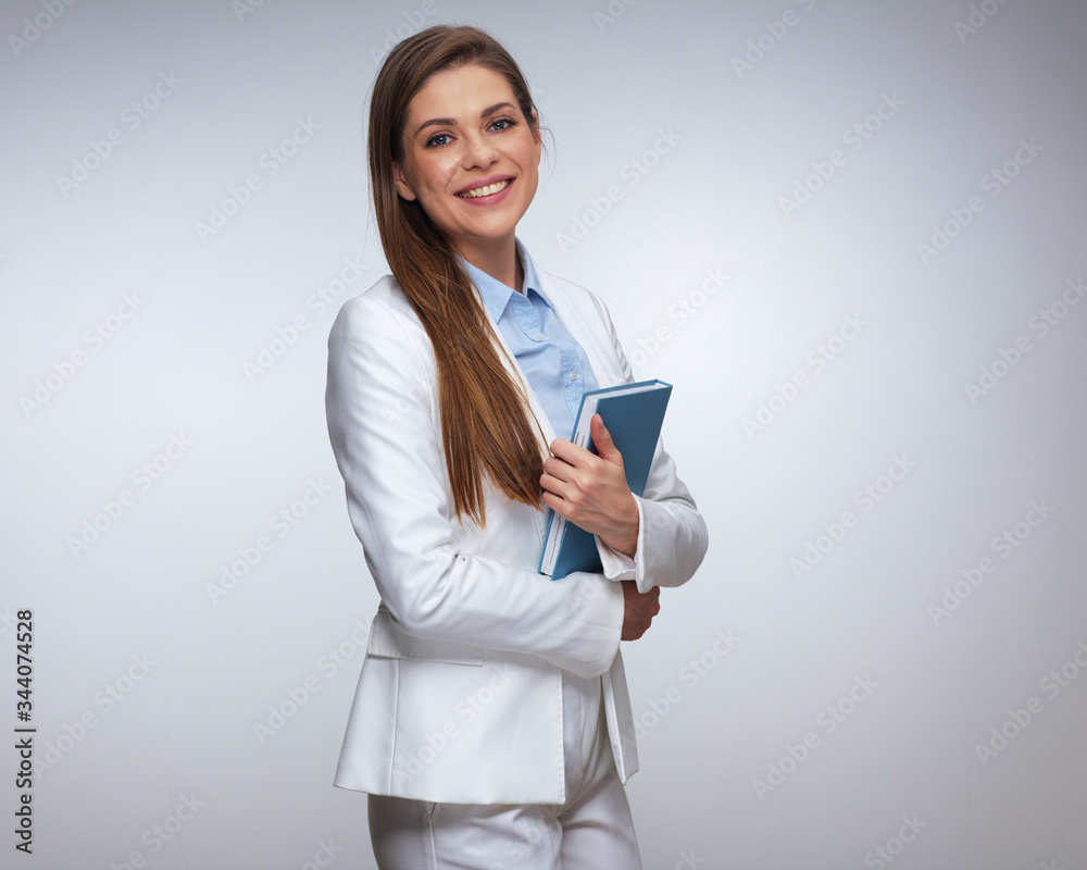 Smiling woman in white business suit holding books. Smiling woman in white business suit holding books.