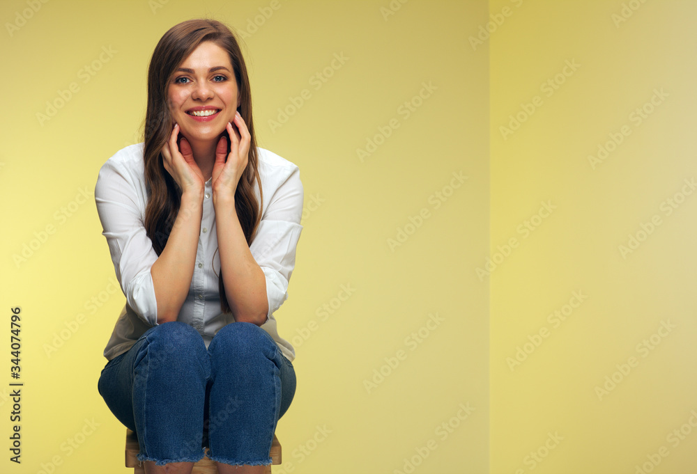 Portrait of smiling woman sitting on stool. Portrait of smiling woman sitting on stool.