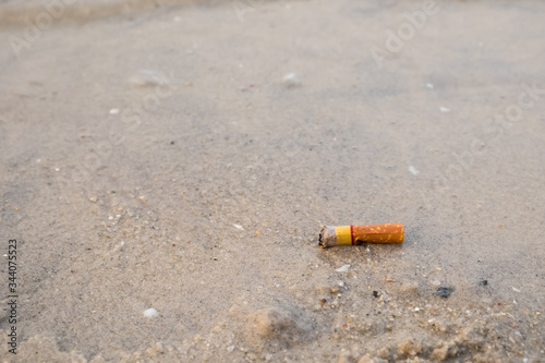 Cigarette butts in the sand on beach.