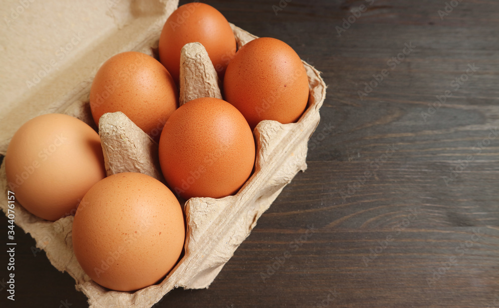 Paper Box of Organic Chicken Eggs Isolated on Wooden Table with Copy Space Paper Box of Organic Chicken Eggs Isolated on Wooden Table with Copy Space