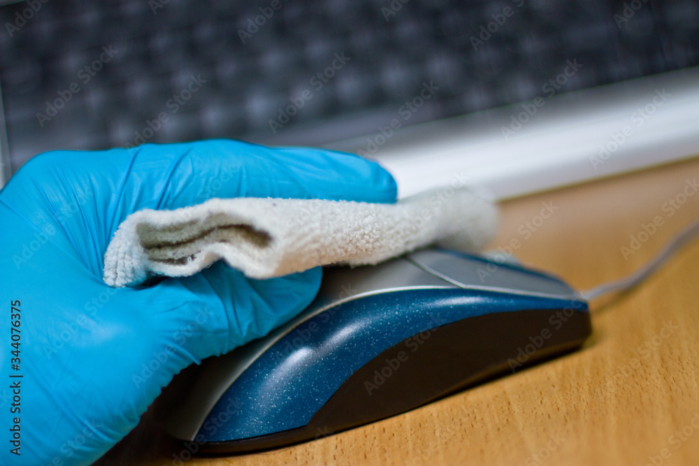 Wipe with antibacterial wipe on the surface of a computer mouse. Coronavirus COVID-19 desktop disinfection Wipe with antibacterial wipe on the surface of a computer mouse. Coronavirus COVID-19 desktop disinfection