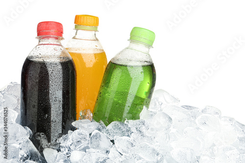 Ice cubes and different soda drinks on white background