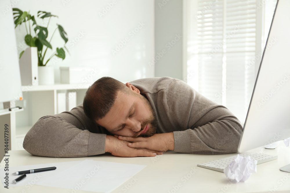 Lazy overweight office employee sleeping at workplace
