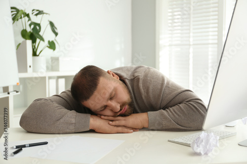 Lazy overweight office employee sleeping at workplace