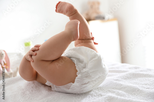 Tableau sur toile Cute little baby in diaper on bed