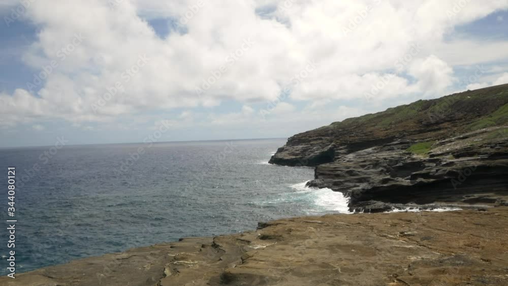 Aerial reveal of ocean waves crashing on the abrupt jagged coastline of Kahauloa Cove, Oahu, Hawaii slow motion Aerial reveal of ocean waves crashing on the abrupt jagged coastline of Kahauloa Cove, Oahu, Hawaii slow motion