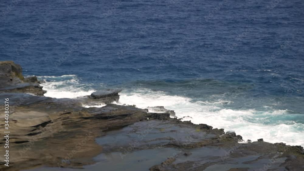 Watching ocean waves crash on and over the abrupt jagged shoreline of Kahauloa Cove, Lanai Lookout, slow motion Watching ocean waves crash on and over the abrupt jagged shoreline of Kahauloa Cove, Lanai Lookout, slow motion