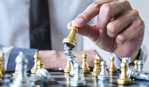 Gold and silver chess with player, Hands of businessman moving chess figure in competition to planning strategy to success play for win