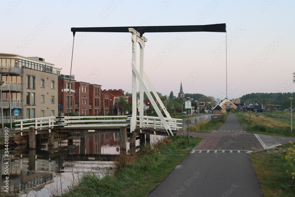Wooden drawbridge called Witte Brug during sunrise in the town of Nieuwerkerk aan den IJssel over the ring canal of the Zuidplaspolder Nederland Wooden drawbridge called Witte Brug during sunrise in the town of Nieuwerkerk aan den IJssel over the ring canal of the Zuidplaspolder Nederland