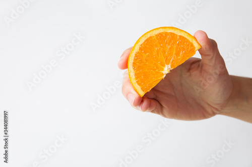 Woman holding orange slice for juice isolated on white background. Cropped shot, closeup. Healthy nutrition or organic food concept