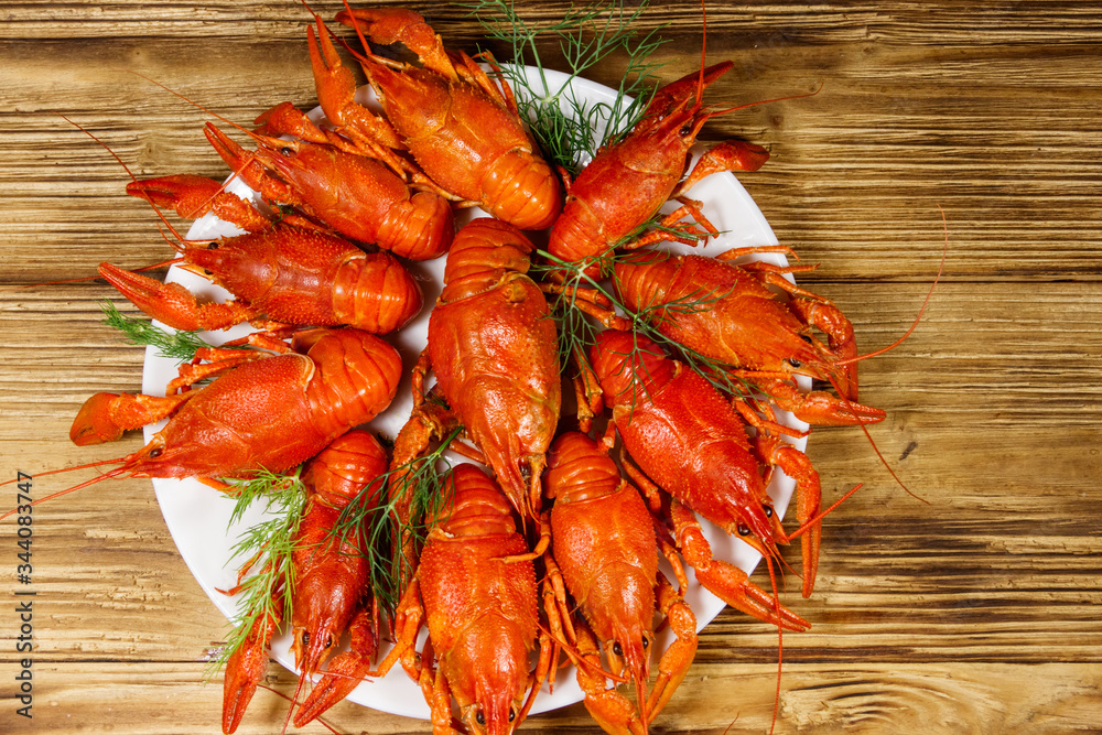 Boiled crayfish in plate on wooden table. Top view Boiled crayfish in plate on wooden table. Top view