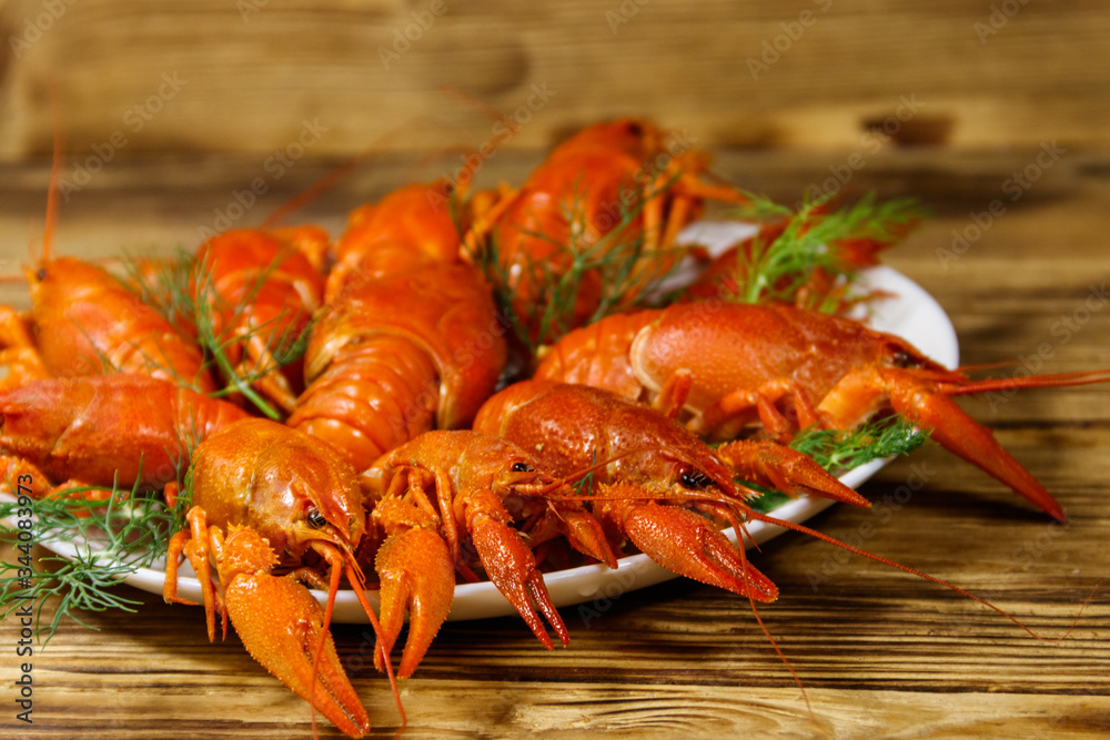 Boiled crayfish in plate on wooden table Boiled crayfish in plate on wooden table