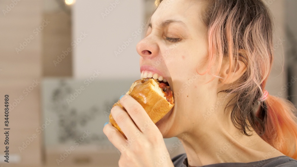 Portrait of caucasian young beautiful woman greedily eagerly eating food during quarantine due to coronavirus. Charming happy hungry woman on diet laugh and biting off big meat pie. Close up.