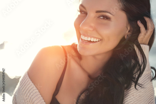 Beautiful woman. Young girl with rays of sunset bill. Portrait. 