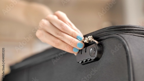 Preparing bag for travel. Freedom, lifestyle, tourism concept. People going on a trip after quarantine. Woman's hand opens or locked the zipper on the travel bag. Female`s hands unzip suitcase.