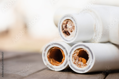 Old broken sludge polypropylene plumbing pipes with red rust and limescale. Corrosion, sludge and hard water concept. Rust broken water pipes