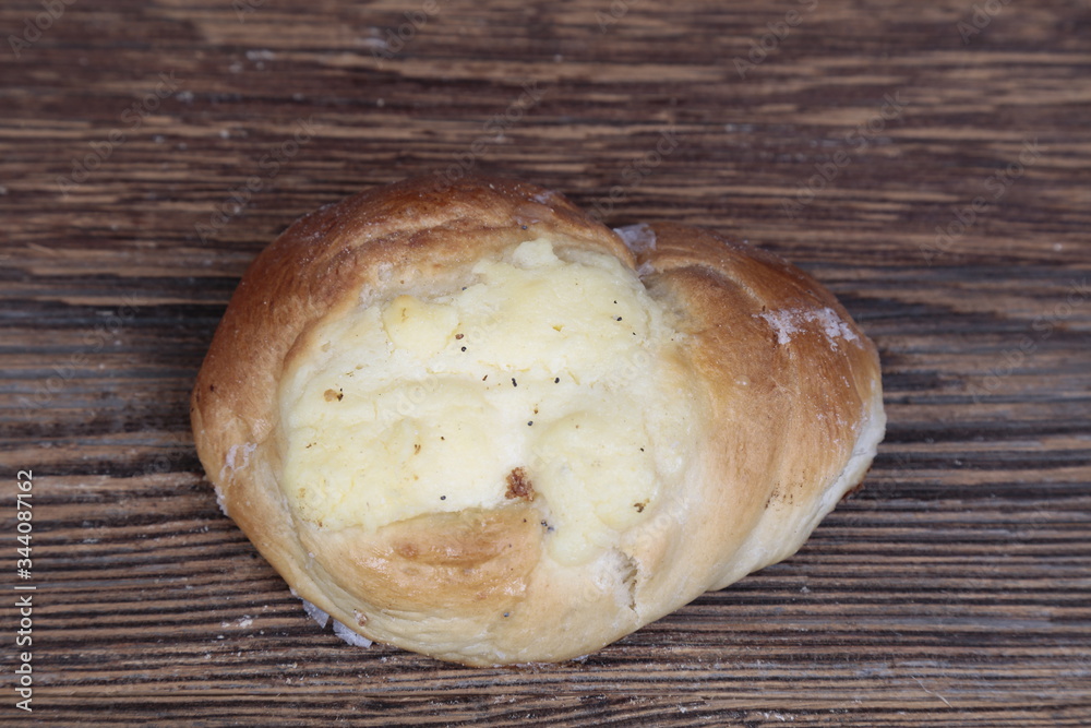 Top view, close-up of a fresh, homemade bun with filling on a wooden, brown, rustic table. Top view, close-up of a fresh, homemade bun with filling on a wooden, brown, rustic table.