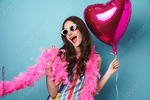 Photo of delighted young woman posing with balloon at camera photo