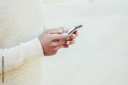 Cropped view of woman texting on smartphone. Closeup view of female hands using modern phone on street. Technology and phone addiction concept