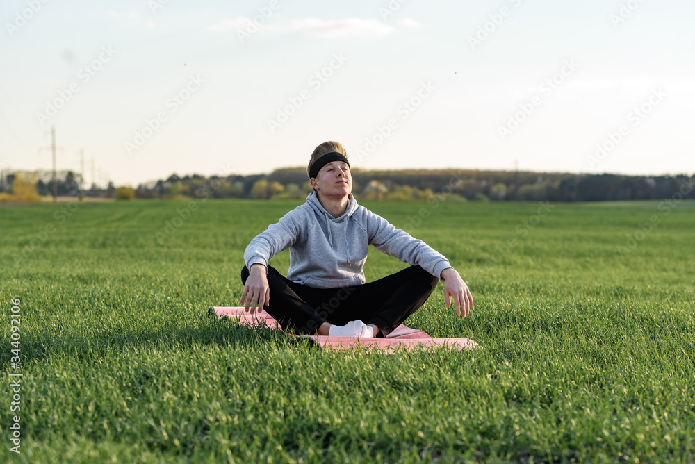 guy meditates in green field holds balance
guy meditates in green field holds balance