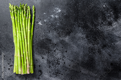 bunch of fresh asparagus on wrought table. Black background. Top view. Copy space