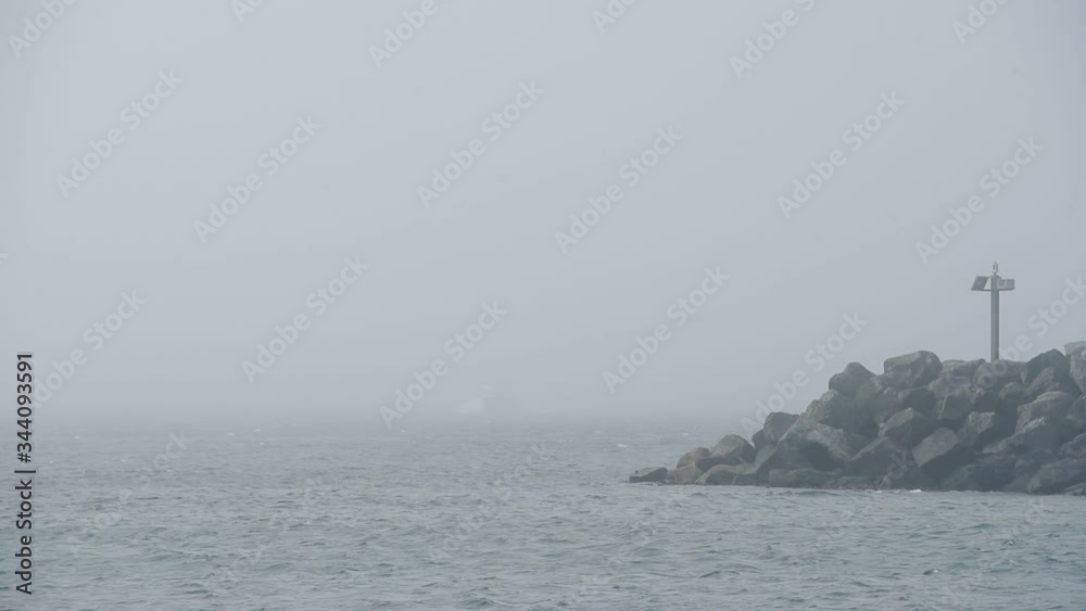 White Ferry Boat Coming Out From The Heavy Fog On Rathlin Island Harbour In Antrim Coast, Northern Ireland.- wide shot White Ferry Boat Coming Out From The Heavy Fog On Rathlin Island Harbour In Antrim Coast, Northern Ireland.- wide shot